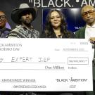Antoinette Banks poses with her award check and Black Ambition CEO Felecia Hatcher, Leonard Creer, and Pharrell Williams